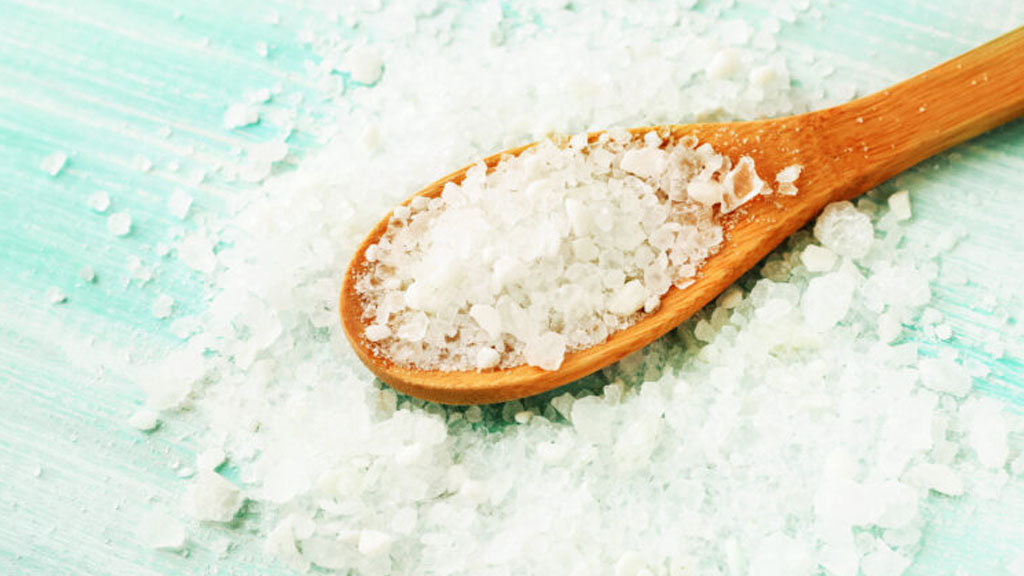 Vagues douces sur rochers côtiers avec cristaux de sel marin visibles évoquant l'origine du magnésium marin