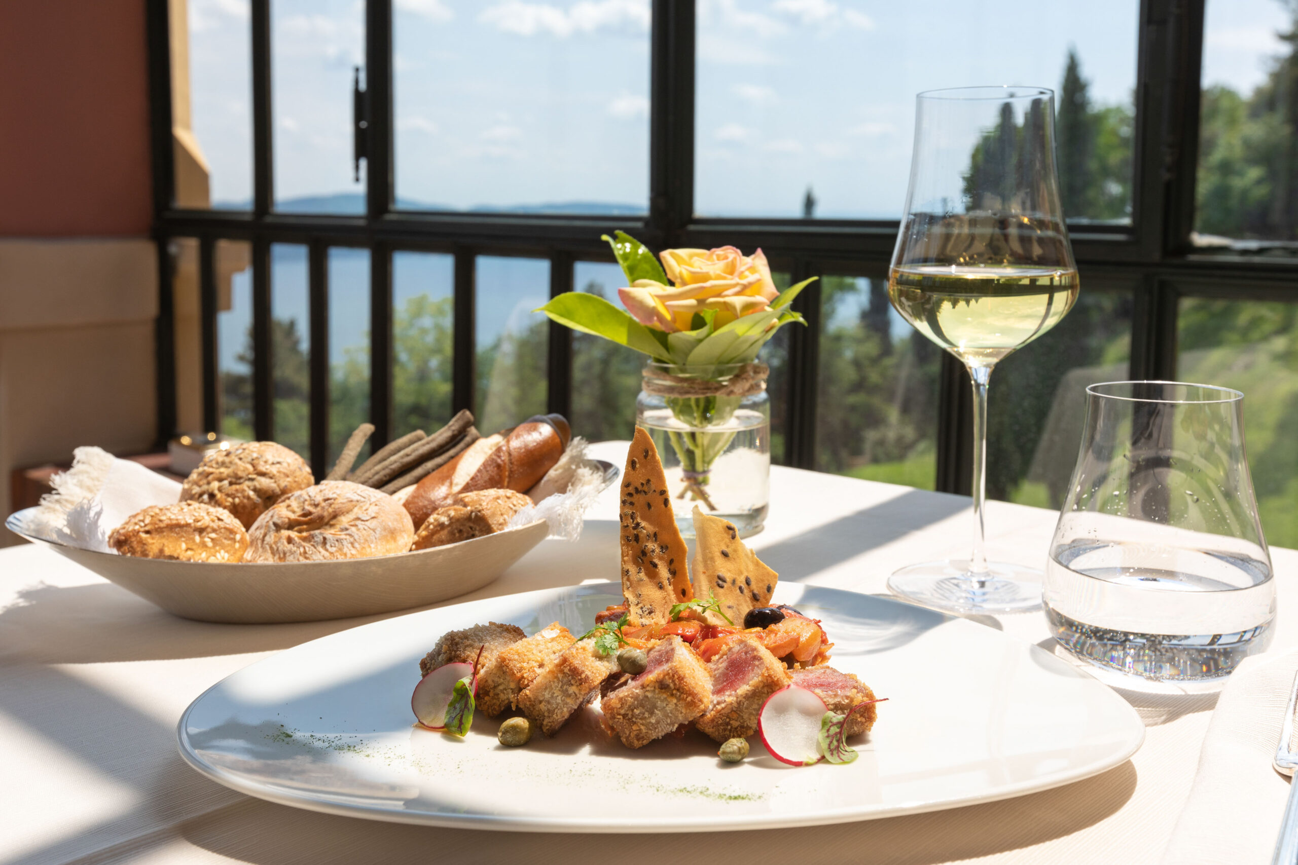 Table gastronomique dressée sur terrasse avec vue sur le lac d'Annecy